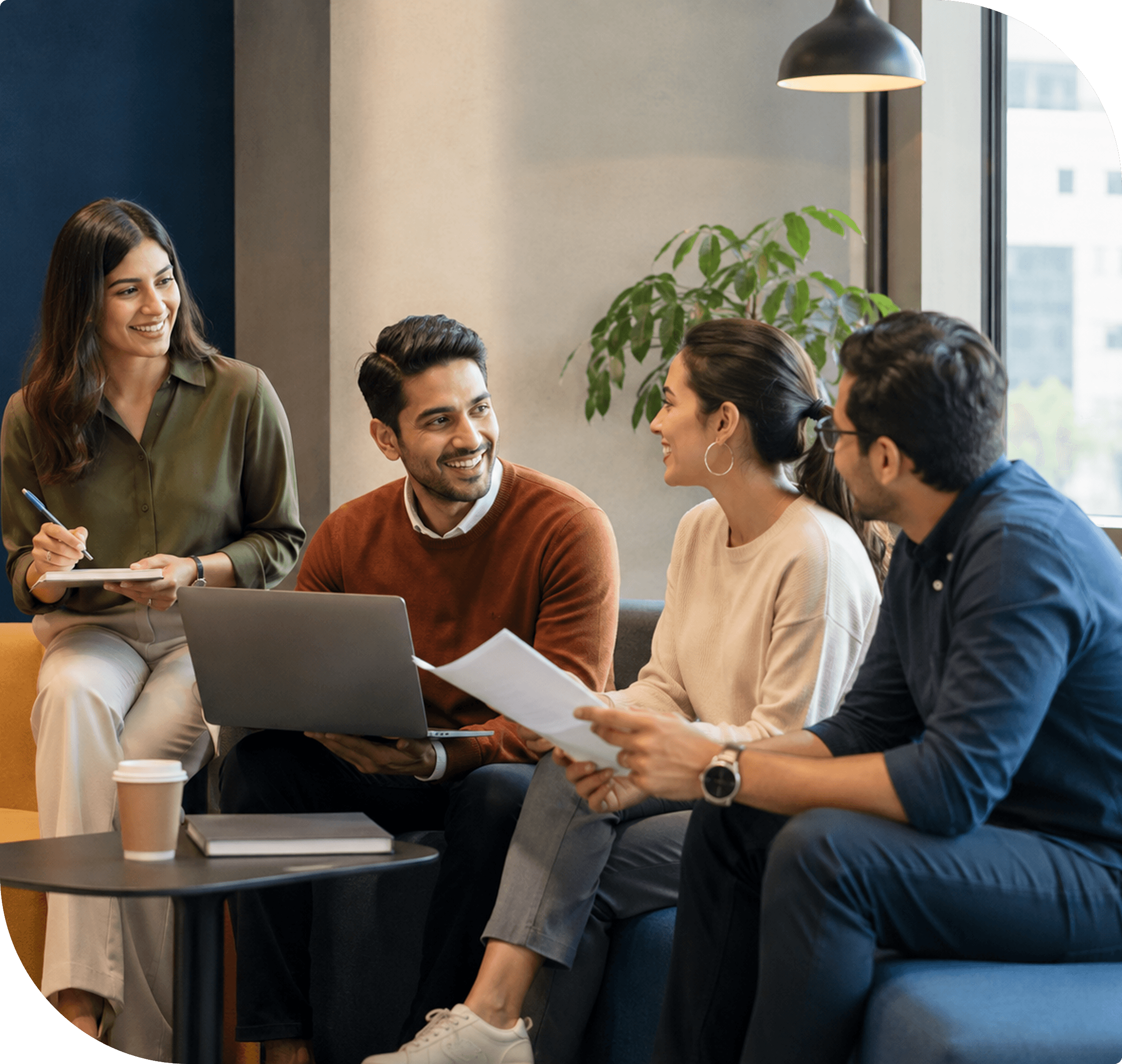 Professionals collaborating around a laptop in a meeting